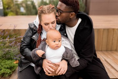 Sokakta bebeği olan genç bir çift.