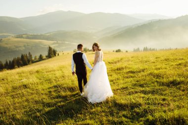 Genç ve güzel bir çift dağlarda poz veriyor.