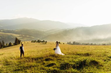 Genç ve güzel bir çift dağlarda poz veriyor.