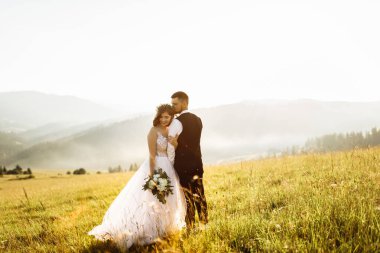 Genç ve güzel bir çift dağlarda poz veriyor.