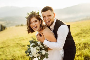 Genç ve güzel bir çift dağlarda poz veriyor.