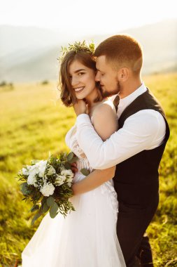 Genç ve güzel bir çift dağlarda poz veriyor.