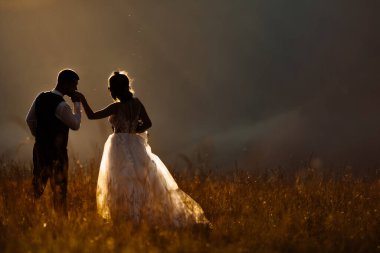 Gün batımında birbirlerine aşık güzel bir çift poz veriyorlar.  