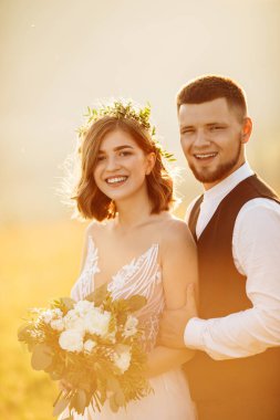 Güzel gelin ve damat doğaya sarılıyor.