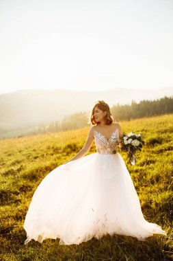 Doğaya poz veren beyaz elbiseli güzel gelin