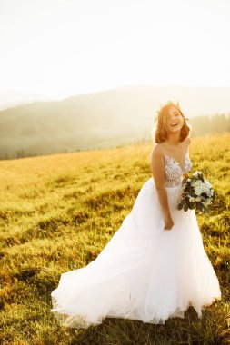 Doğaya poz veren beyaz elbiseli güzel gelin