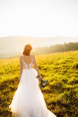 Doğaya poz veren beyaz elbiseli güzel gelin