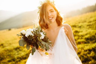 Doğaya poz veren beyaz elbiseli güzel gelin