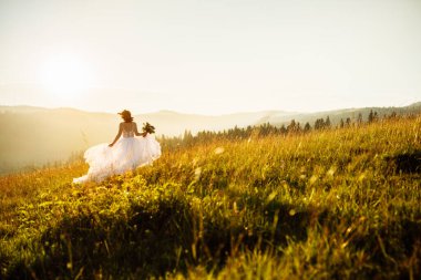 Doğaya poz veren beyaz elbiseli güzel gelin