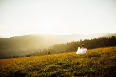 Doğaya poz veren beyaz elbiseli güzel gelin