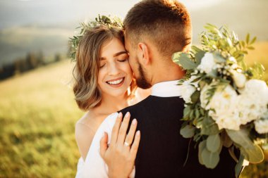 Doğada poz veren güzel bir düğün çifti.