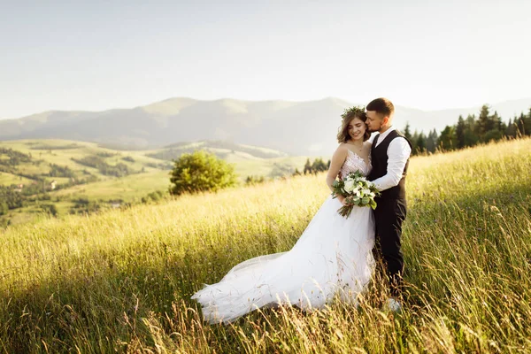 美しい花嫁と新郎が山の中でポーズをとって — ストック写真