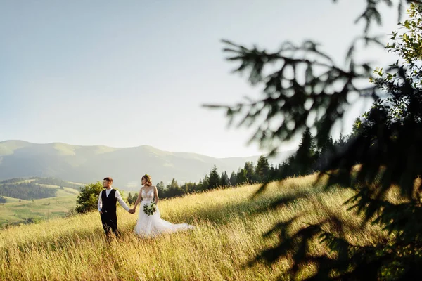 Güzel genç bir çift dağlarda yürüyor.