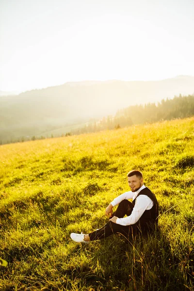 幸せな若い新郎緑の草の上に座って — ストック写真
