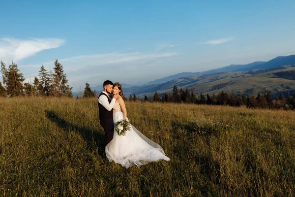 美しい若い結婚式のカップルが山を背景にポーズをとって — ストック写真