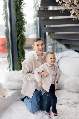 Küçük bebek ve babası evde eğleniyor. 