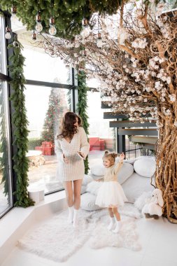 Güzel genç anne ve küçük kızı Noel zamanı evde eğleniyorlar. 