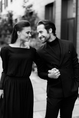 Yakışıklı bir adam ve güzel bir kadının siyah beyaz portresi. Moda mutlu çifti buluşuyor, birlikte vakit geçiriyorlar, dışarıda poz veriyorlar..  