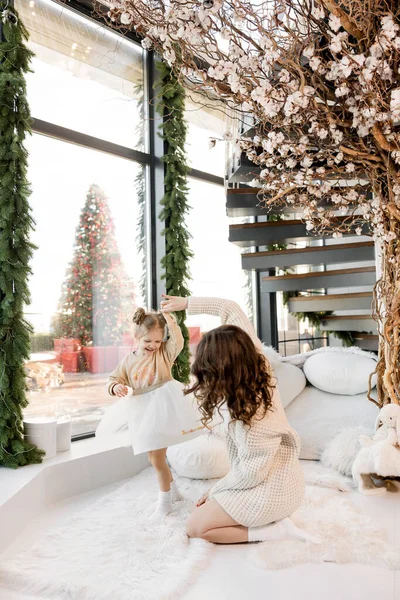 Güzel genç anne ve küçük kızı Noel zamanı evde eğleniyorlar. 