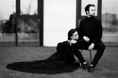 Siyah elbiseli fotoşopları olan beyaz bir çift. Güzel genç bir kadın, büyüleyici sakallı adamın yanında poz veriyor..