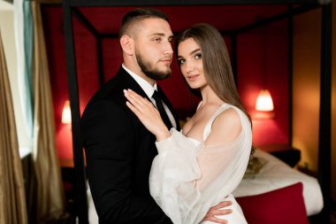 Güzel, genç ve aşık bir çift odada poz veriyor.