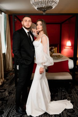 Güzel gelin ve damat bir otel odasında.