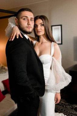 Güzel, genç ve aşık bir çift odada poz veriyor.