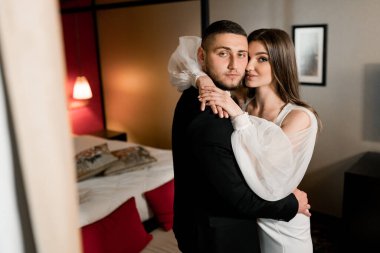 Güzel, genç ve aşık bir çift odada poz veriyor.