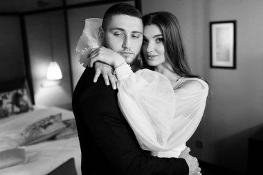 Güzel, genç ve aşık bir çift odada poz veriyor.