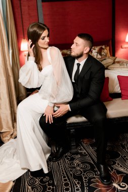 Güzel, genç ve aşık bir çift odada poz veriyor.