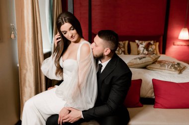 Güzel, genç ve aşık bir çift odada poz veriyor.