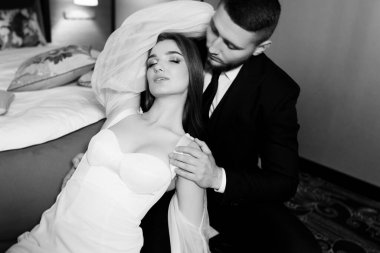 Güzel, genç ve aşık bir çift odada poz veriyor.