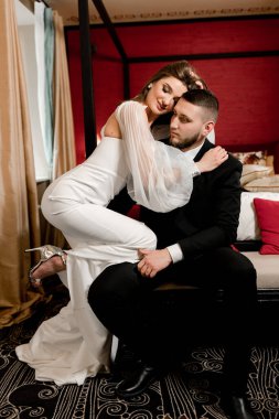 Güzel, genç ve aşık bir çift odada poz veriyor.