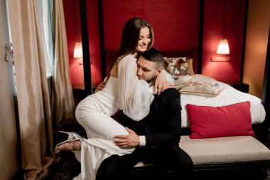 Güzel, genç ve aşık bir çift odada poz veriyor.