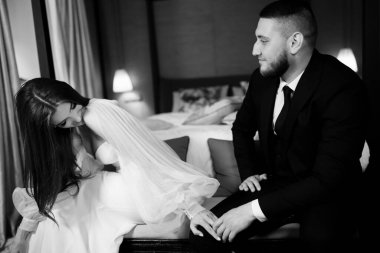 Yatak odasında birbirine aşık güzel bir çiftin siyah beyaz portresi.