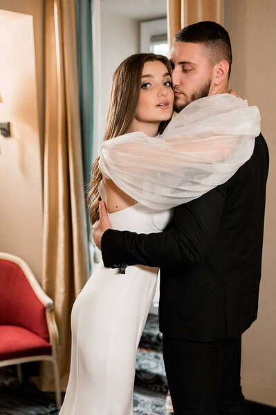 beautiful bride and groom in a hotel room interior