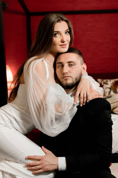 Güzel, genç ve aşık bir çift odada poz veriyor.