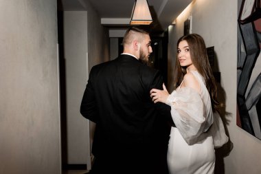 Güzel gelin ve damat koridorda poz veriyor.