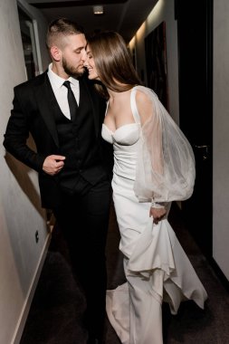 Güzel gelin ve damat koridorda poz veriyor.