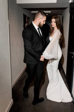 Güzel gelin ve damat koridorda poz veriyor.