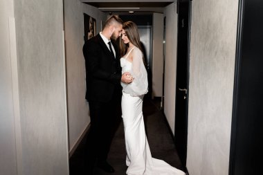 Güzel gelin ve damat koridorda poz veriyor.