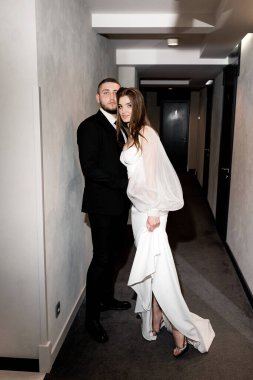 Güzel gelin ve damat koridorda poz veriyor.