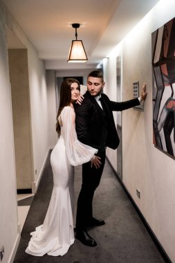 Güzel gelin ve damat koridorda poz veriyor.