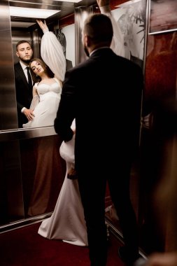 Gelin ve damat asansörde poz veriyorlar.