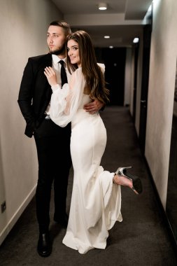 Güzel gelin ve damat koridorda poz veriyor.