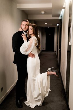 Güzel gelin ve damat koridorda poz veriyor.