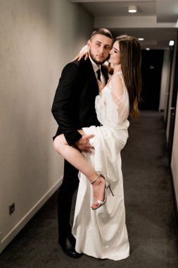 Güzel gelin ve damat koridorda poz veriyor.