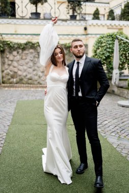 Gelin ve damat düğün günlerinde dışarıda poz veriyorlar.