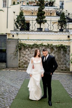 Gelin ve damat düğün günlerinde dışarıda poz veriyorlar.