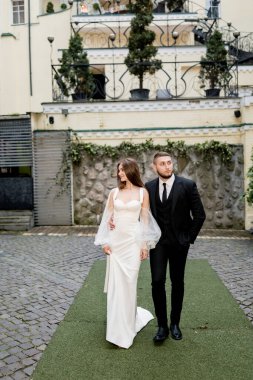 Güzel, genç ve aşık bir çift şehir geçmişinde poz veriyor.